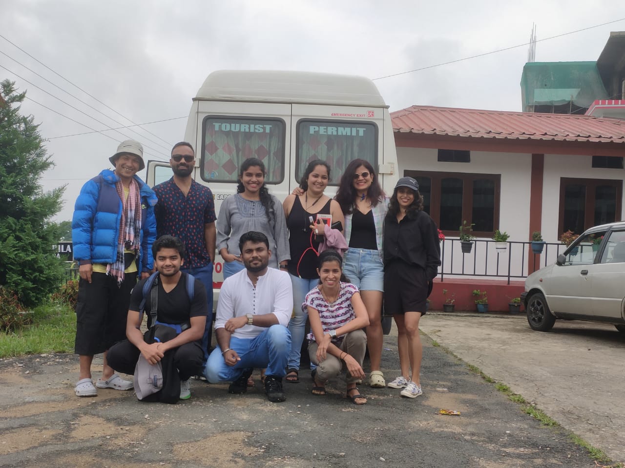 Happy travellers beside their tour vehicle during a Meghalaya journey